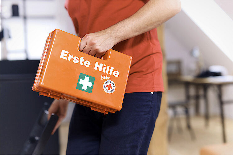 Erste Hilfe Koffer Ein Mann trägt einen Erste Hilfe Koffer