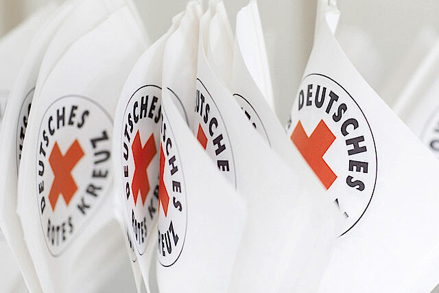 mehrere kleine Fahnen mit DRK-Logo