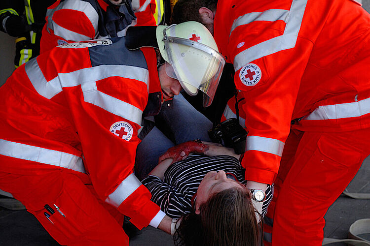 Helfer kümmern sich um eine verletzte Person