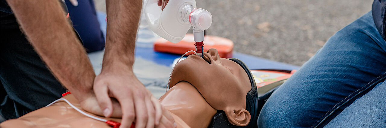 Eine Person macht an einem Torso Herzmassage, eine andere Person setzt einen Tubus